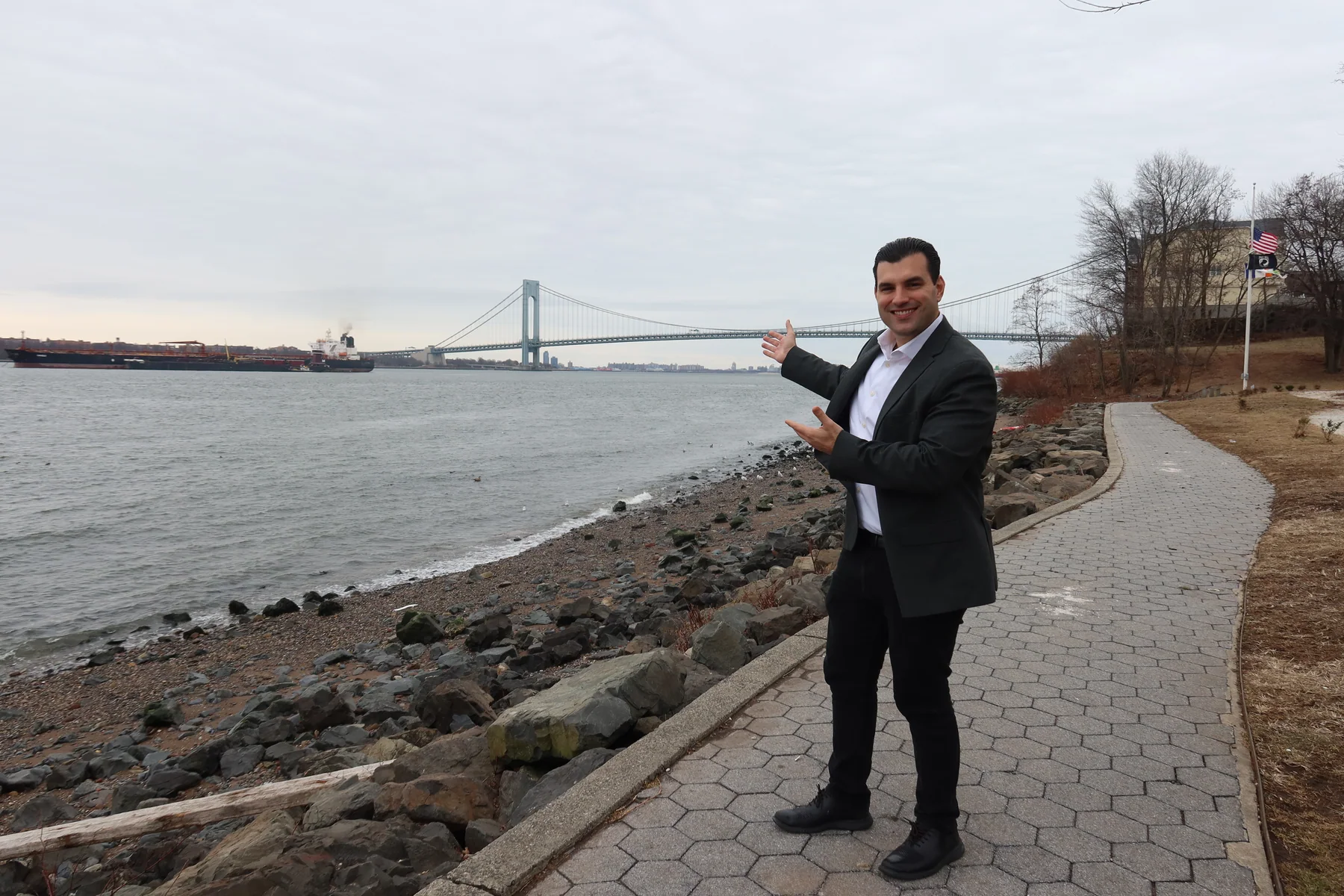 Joseph Ranola on the Staten Island shoreline with the Verrazzano-Narrows Bridge to Brooklyn behind him